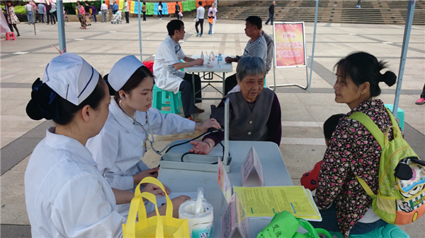 近日，梧州市總工會在市政廣場舉辦服務職工和農民工活動，10多個基層工會參與服務活動，圖為醫(yī)療系統(tǒng)組織勞模志愿隊免費義診，